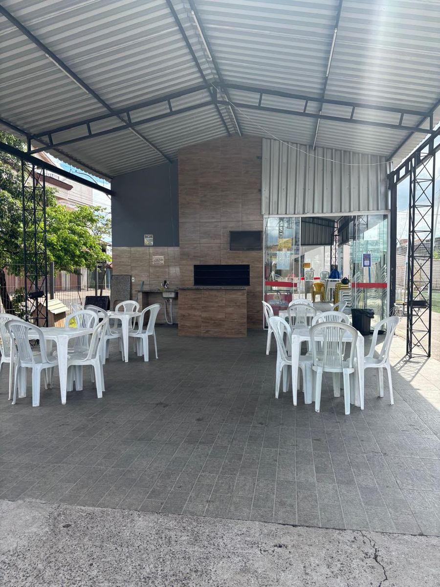 Área coberta com mesas e churrasqueira
